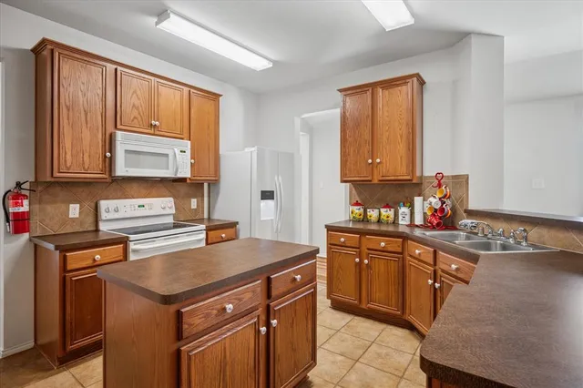 a kitchen with a sink stove top oven and cabinets