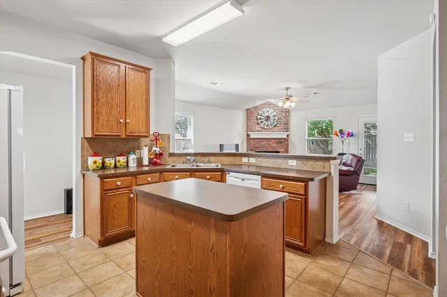 a kitchen with kitchen island granite countertop a sink stove and cabinets