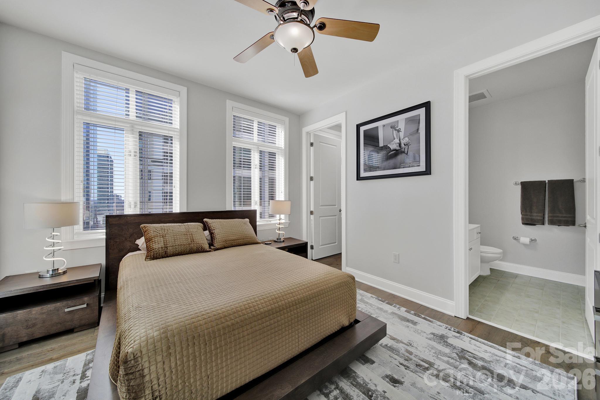 230 South Tryon Street, Unit 1004 Charlotte, NC 28281 - Photo 21 of 39 a bedroom with a bed and a chandelier