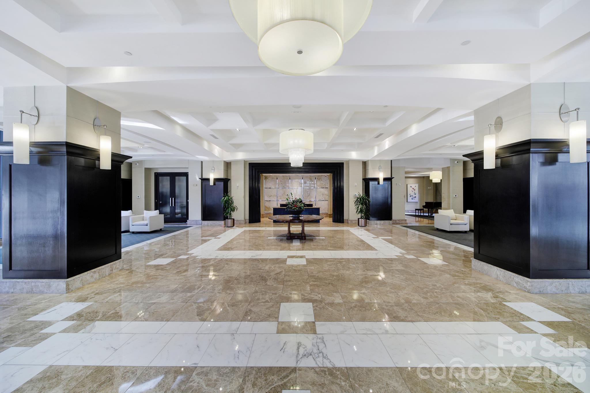 230 South Tryon Street, Unit 1004 Charlotte, NC 28281 - Photo 38 of 39 a view of a kitchen with living room and a chandelier