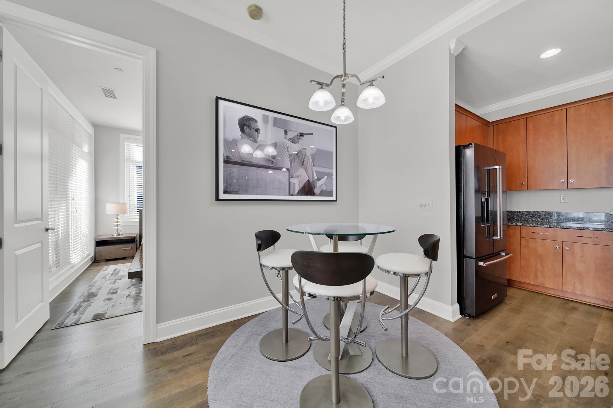230 South Tryon Street, Unit 1004 Charlotte, NC 28281 - Photo 8 of 39 a view of a dining room with furniture a chandelier and wooden floor