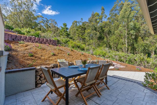 a view of a patio with table and chairs with wooden floor and fence