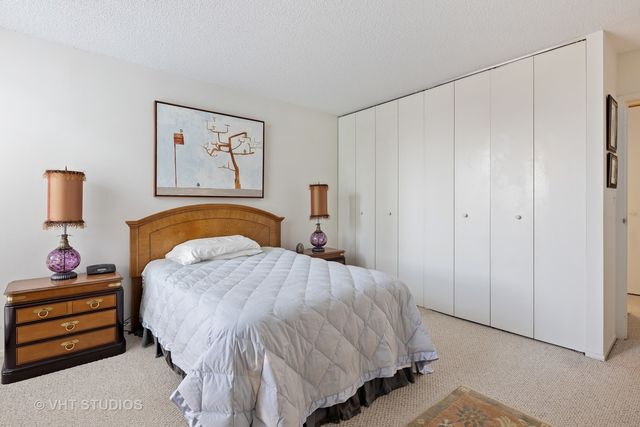 a living room with furniture a rug and wall paintings