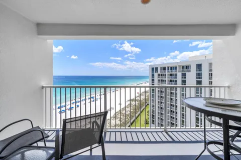 a view of a balcony with furniture and floor to ceiling window