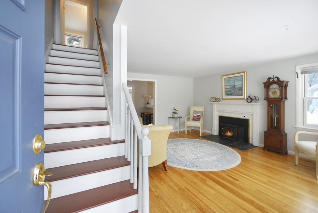 82 Powers Road Concord, MA 01742 - Photo 22 of 35 a view of a livingroom with a fireplace a ceiling fan and windows