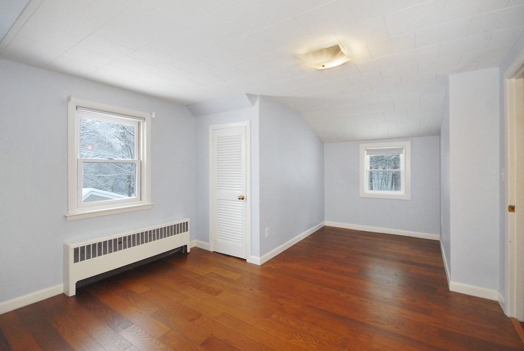 82 Powers Road Concord, MA 01742 - Photo 24 of 35 a view of an empty room with wooden floor and a window