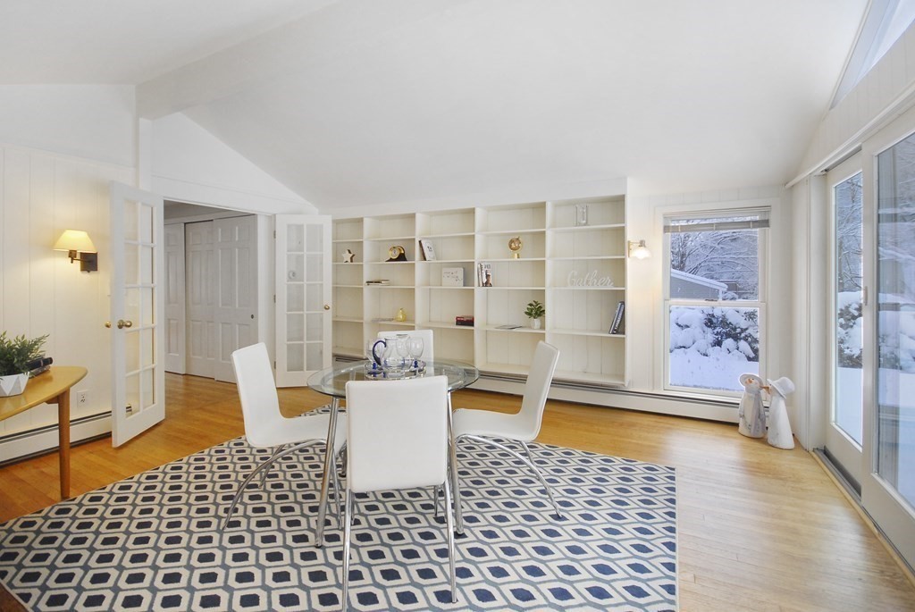82 Powers Road Concord, MA 01742 - Photo 3 of 35 a living room with a black white checkered floor with a dining table and chair