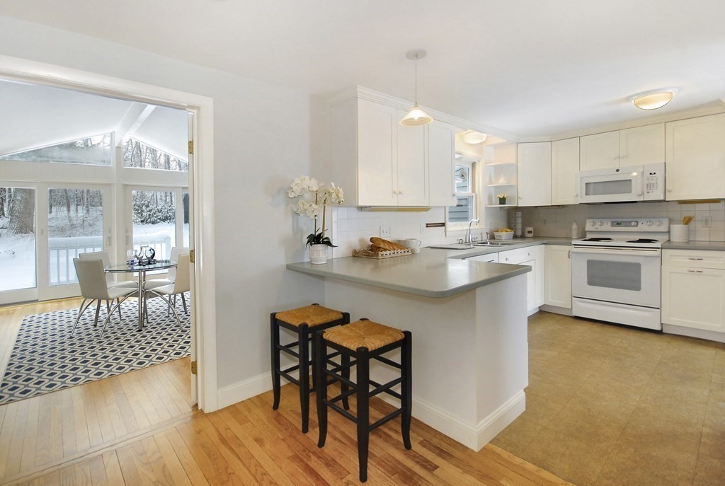 82 Powers Road Concord, MA 01742 - Photo 5 of 35 a kitchen with a table chairs stove and cabinets