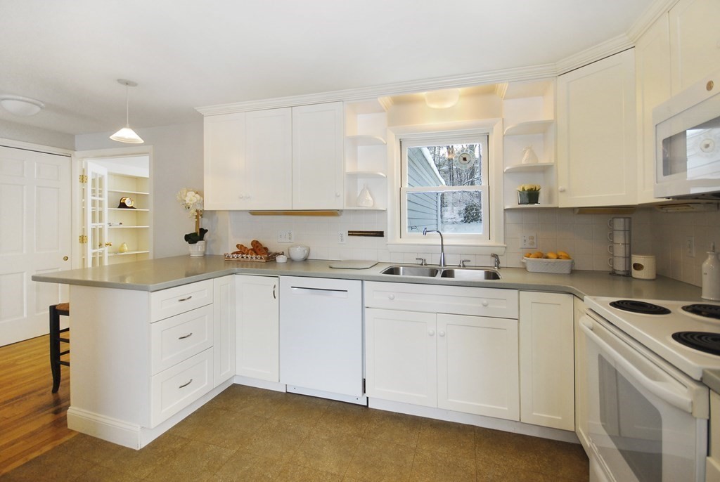 82 Powers Road Concord, MA 01742 - Photo 6 of 35 a kitchen with granite countertop white cabinets and white appliances