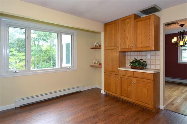 50 Gilbert Road Needham, MA 02492 - Photo 7 of 25 a kitchen with wooden floors and white cabinets