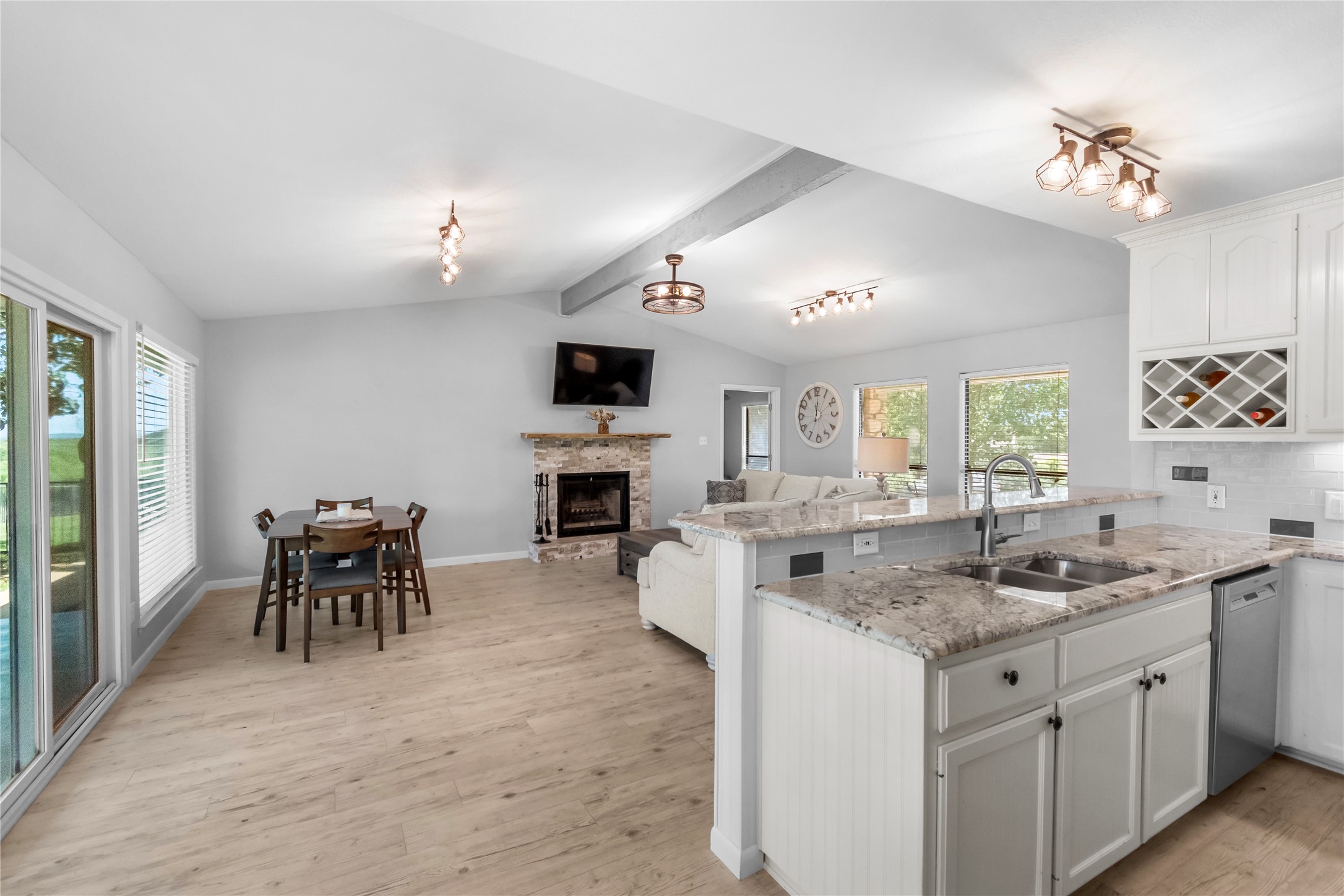 210 Teeoff, Unit B Horseshoe Bay, TX 78657 - Photo 11 of 38 Granite counters and light wood flooring define this open-concept kitchen and living area, complete with a cozy fireplace.