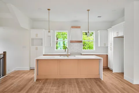a view of a kitchen with wooden floor and a ceiling fan