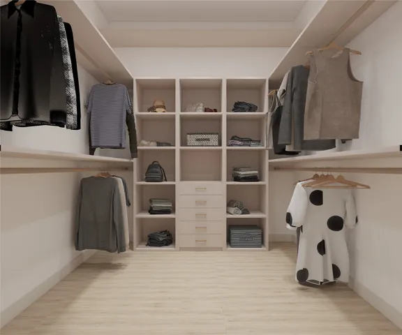 a view of walk in closet with clothes and shoes