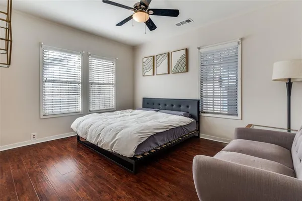 a view of a bedroom with baby crib and wooden floor