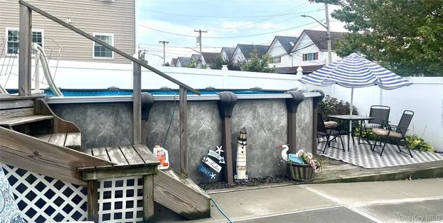 a view of a patio with table and chairs with wooden floor and fence