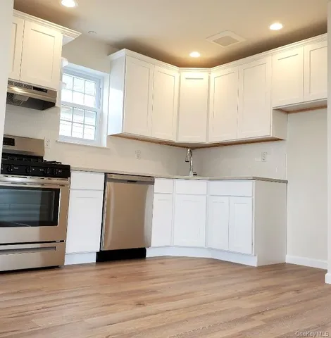 a kitchen with granite countertop a stove a sink and a microwave