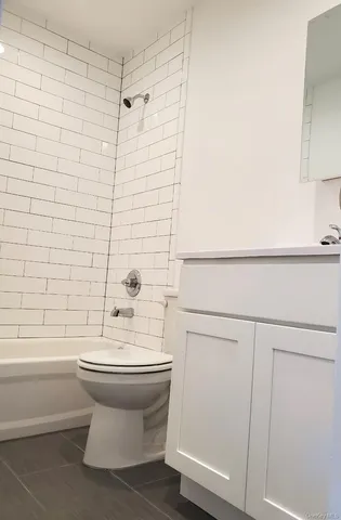 a bathroom with a white toilet and a bathtub