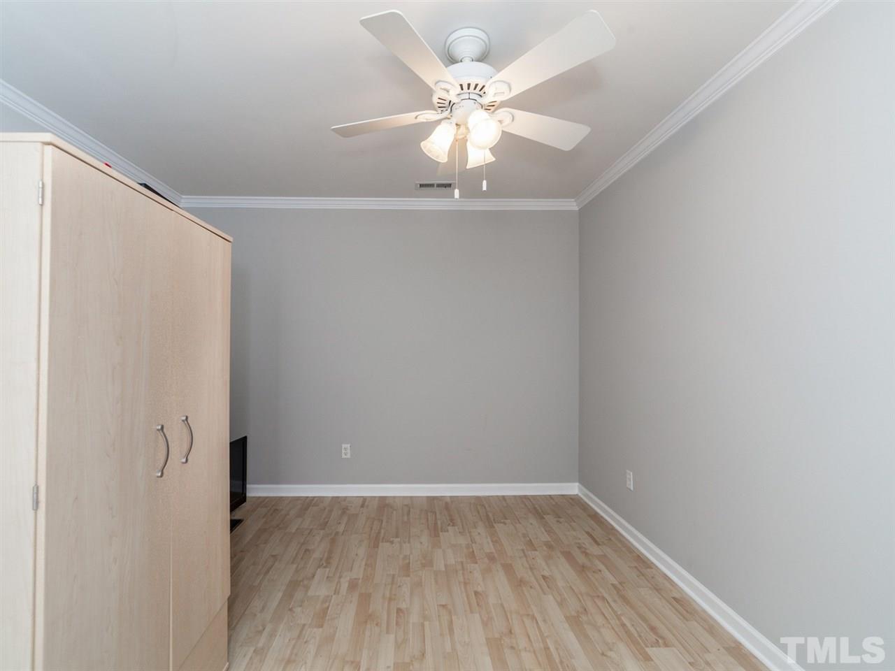 7030 Sandy Forks Road, Unit 102 Raleigh, NC 27615 - Photo 23 of 25 a view of a room with wooden floor and a ceiling fan