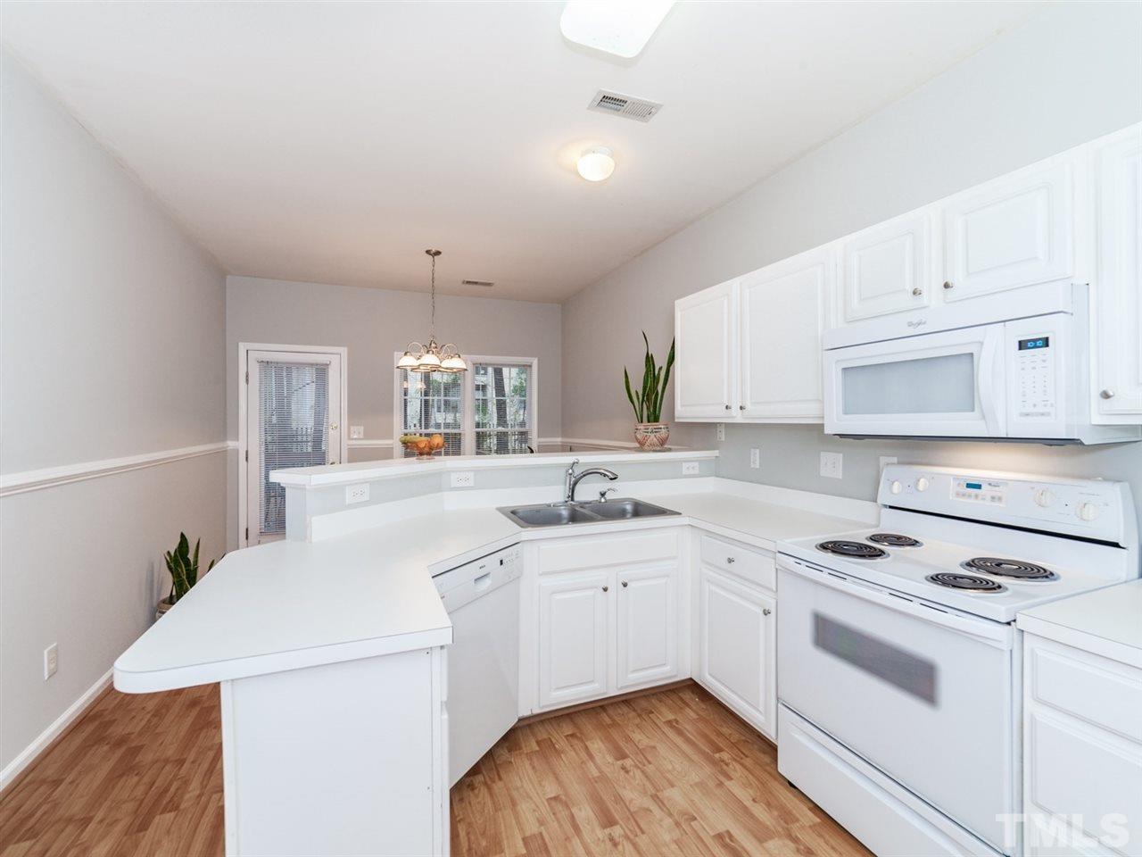 7030 Sandy Forks Road, Unit 102 Raleigh, NC 27615 - Photo 5 of 25 a kitchen with a stove a sink and a refrigerator