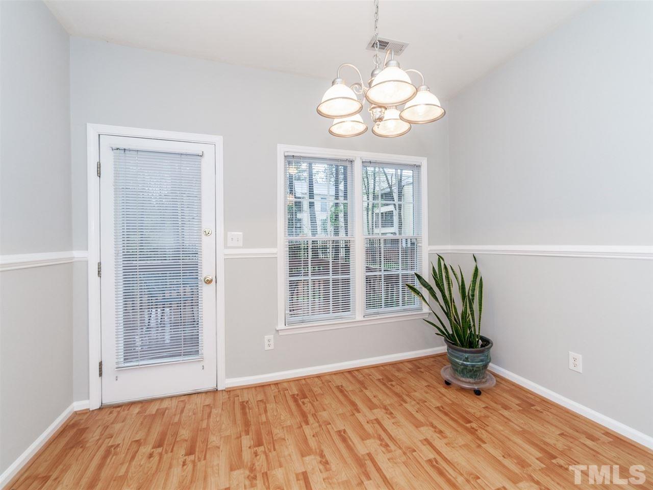 7030 Sandy Forks Road, Unit 102 Raleigh, NC 27615 - Photo 7 of 25 a view of an empty room with wooden floor and a window