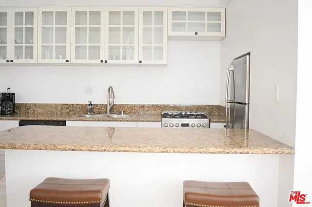 a view of a kitchen with kitchen island and a sink