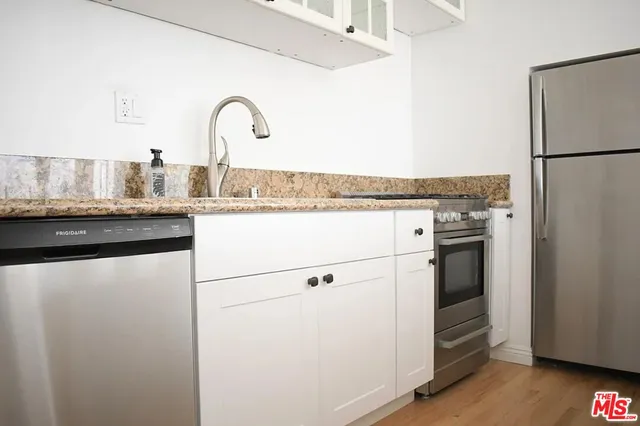 a close view of a kitchen with a sink and a refrigerator
