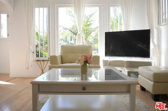 a view of living room with a flat screen tv and windows
