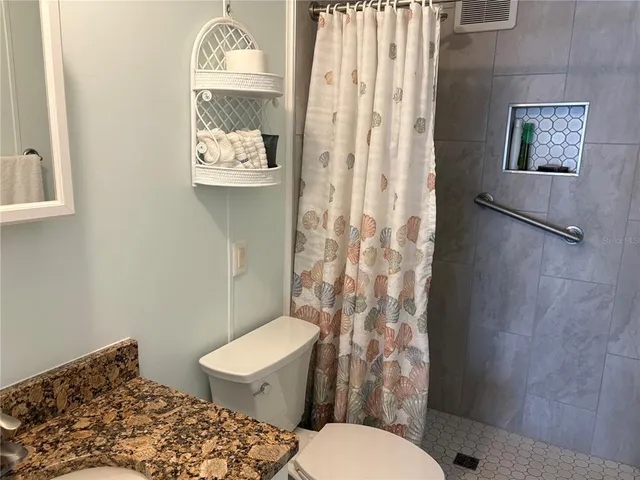 a white toilet sitting next to a shower curtain