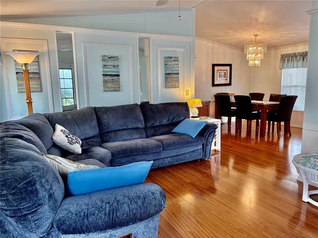 a living room with furniture wooden floor and dining table