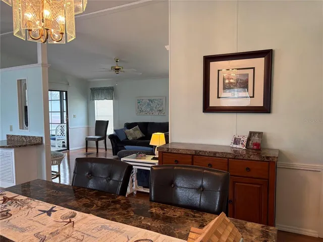 a living room with stainless steel appliances kitchen island granite countertop a stove a sink and a refrigerator