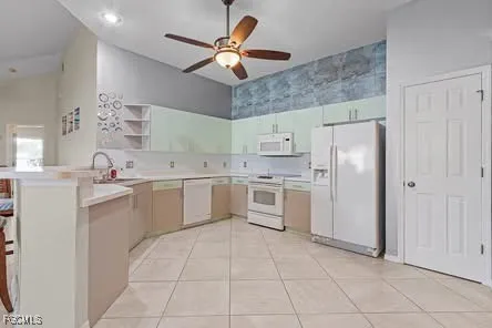 a kitchen with a stove a refrigerator and white cabinets