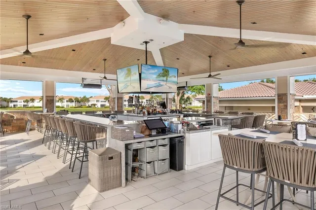 a kitchen with stainless steel appliances kitchen island granite countertop a table chairs sink and white cabinets