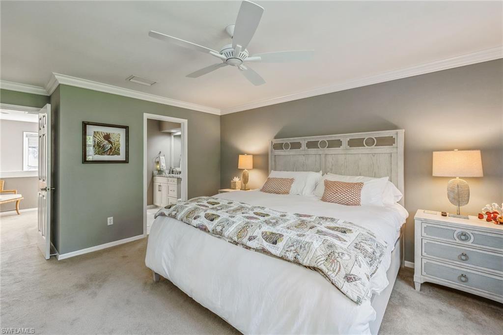 6652 Trident Way, Unit J1 Naples, FL 34108 - Photo 17 of 20 a bedroom with a bed and a chandelier