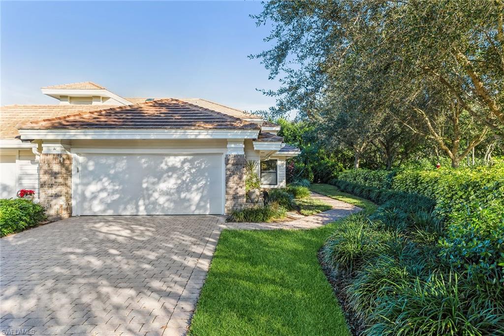 6652 Trident Way, Unit J1 Naples, FL 34108 - Photo 19 of 20 a view of a house with yard and a garden