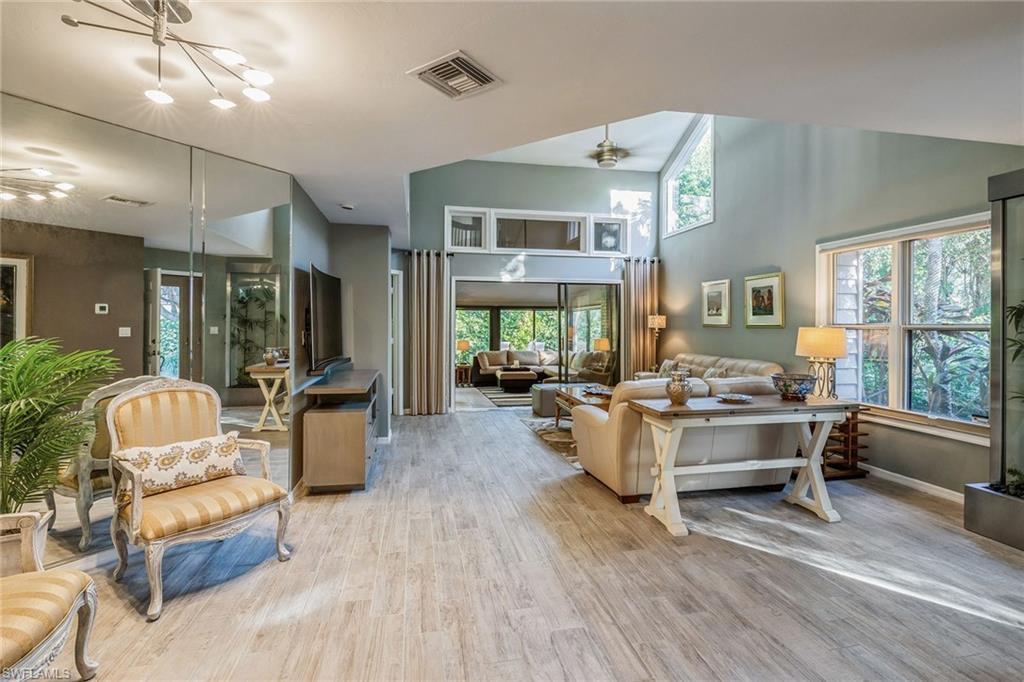 6652 Trident Way, Unit J1 Naples, FL 34108 - Photo 2 of 20 a living room with fireplace furniture and a large window