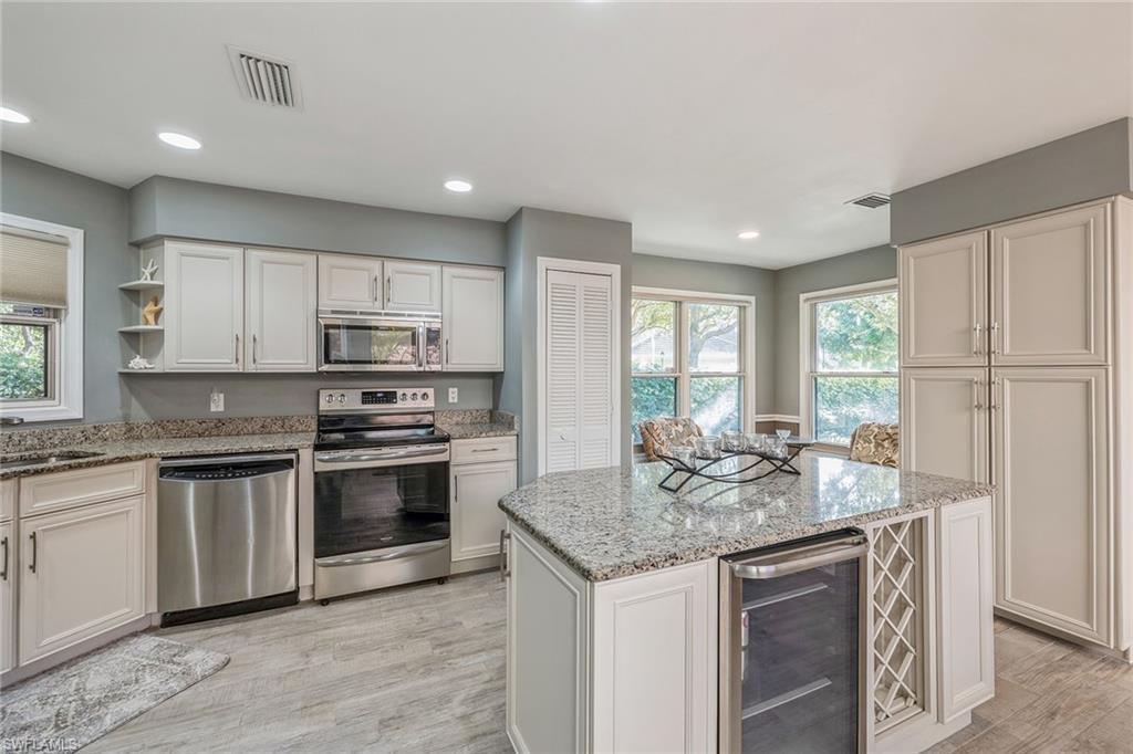 6652 Trident Way, Unit J1 Naples, FL 34108 - Photo 5 of 20 a kitchen with stainless steel appliances granite countertop a sink stove and refrigerator