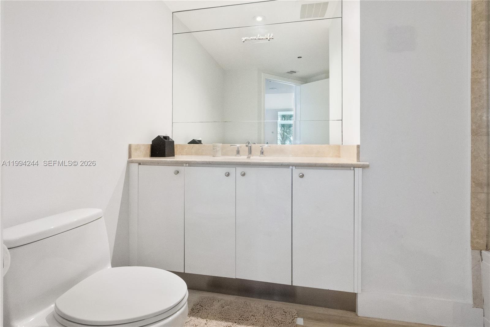 901 Brickell Key Boulevard, Unit 305 Miami, FL 33131 - Photo 20 of 31 a bathroom with a toilet a sink and mirror
