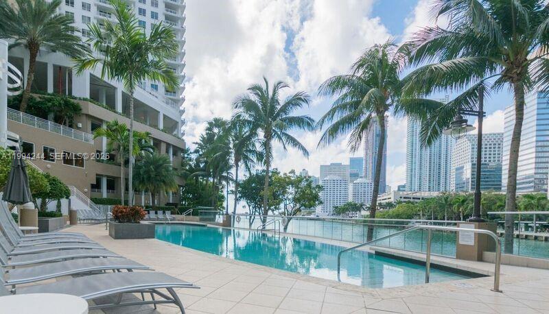 901 Brickell Key Boulevard, Unit 305 Miami, FL 33131 - Photo 28 of 31 a view of swimming pool with outdoor seating and plants
