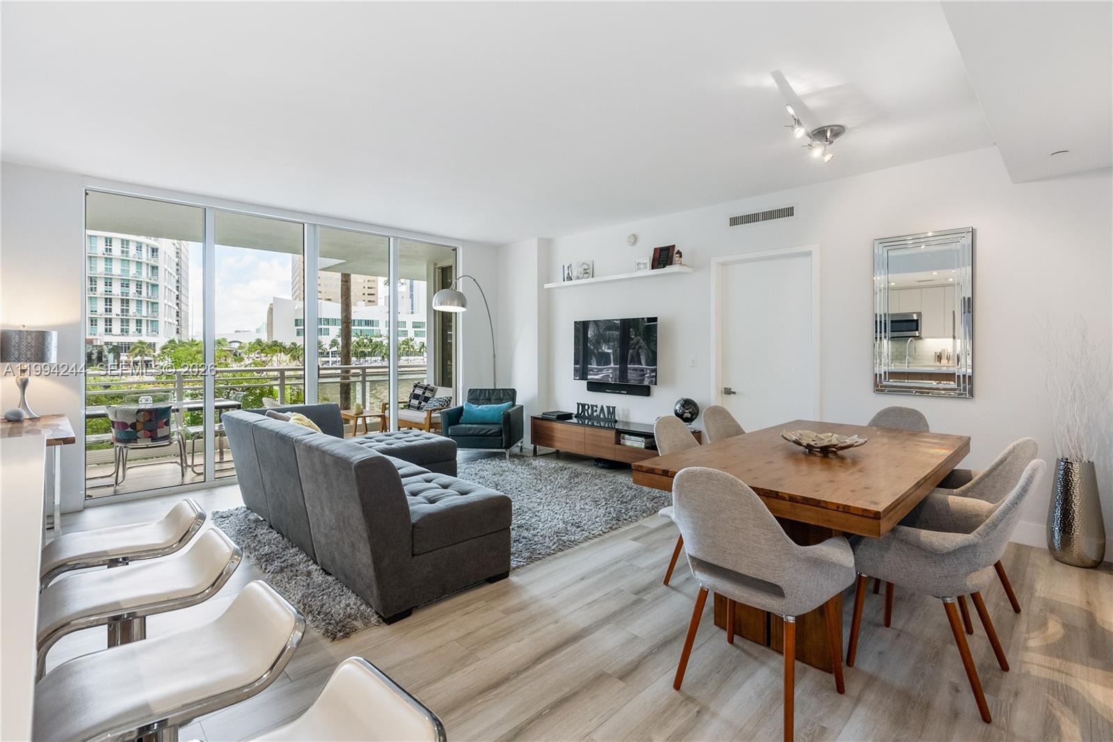 901 Brickell Key Boulevard, Unit 305 Miami, FL 33131 - Photo 8 of 31 a living room with furniture and a flat screen tv