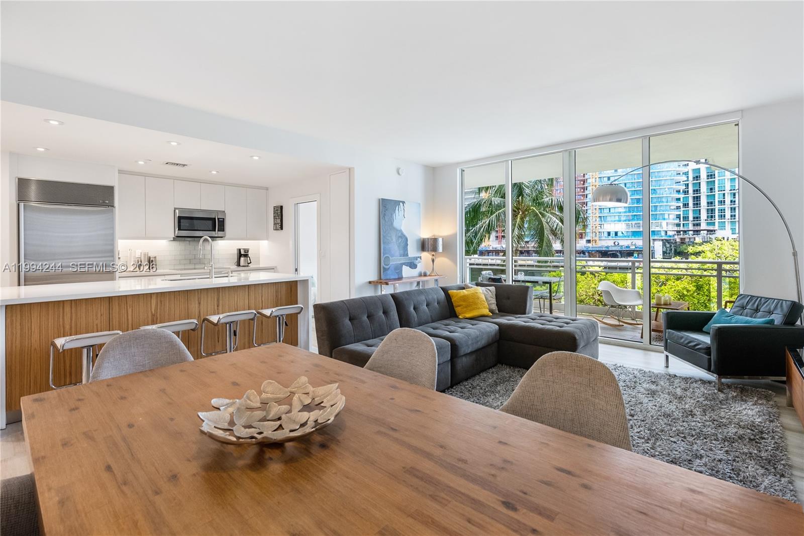 901 Brickell Key Boulevard, Unit 305 Miami, FL 33131 - Photo 10 of 31 a living room with furniture kitchen view and large windows
