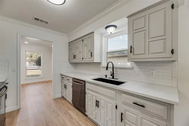 a kitchen with stainless steel appliances granite countertop a sink a stove and cabinets