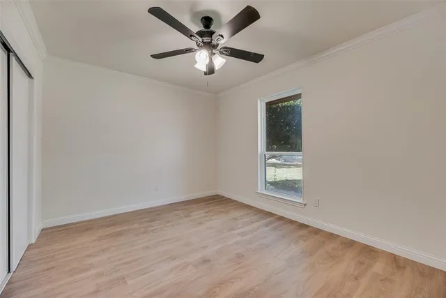 an empty room with a window and a fan