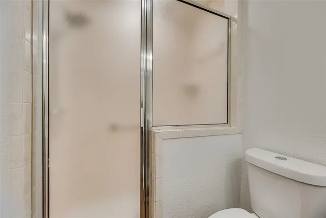 a white toilet sitting next to a shower