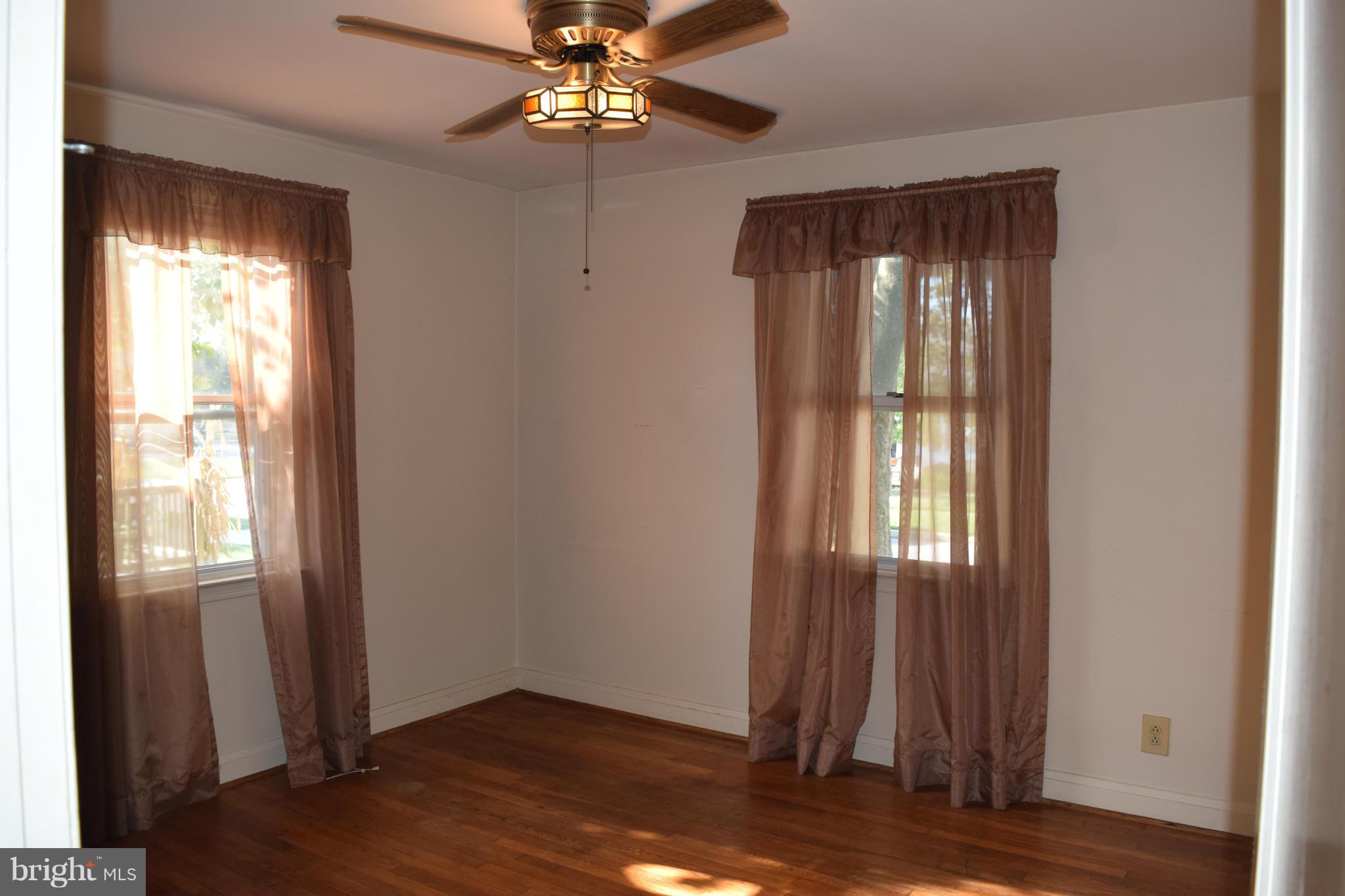 1529 Leslie Road Baltimore, MD 21222 - Photo 11 of 23 an empty room with wooden floor fan and windows