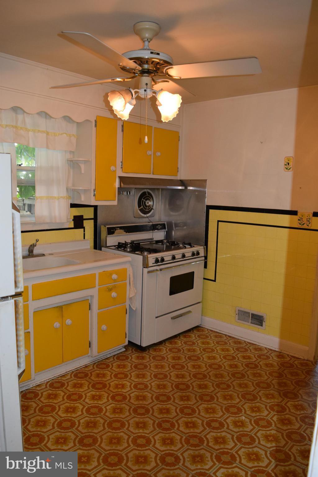 1529 Leslie Road Baltimore, MD 21222 - Photo 14 of 23 a kitchen with a stove a sink and a refrigerator
