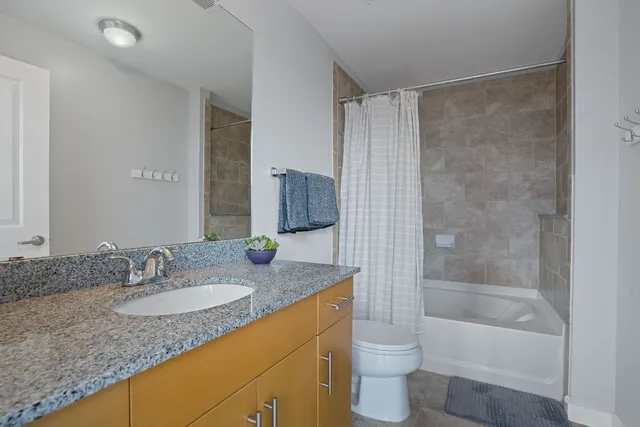 a bathroom with a granite countertop sink toilet and shower