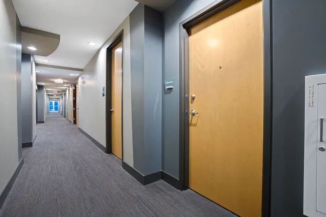 a view of a hallway with wooden floor