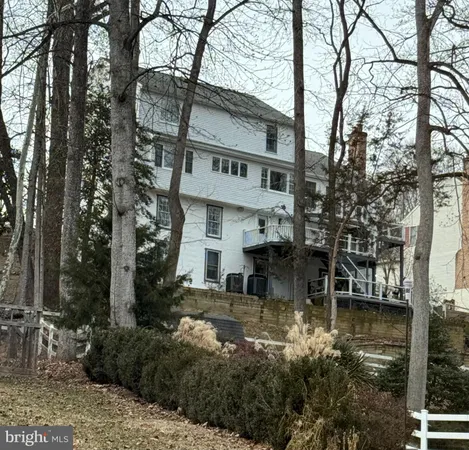 a view of a building with a small yard and large tree