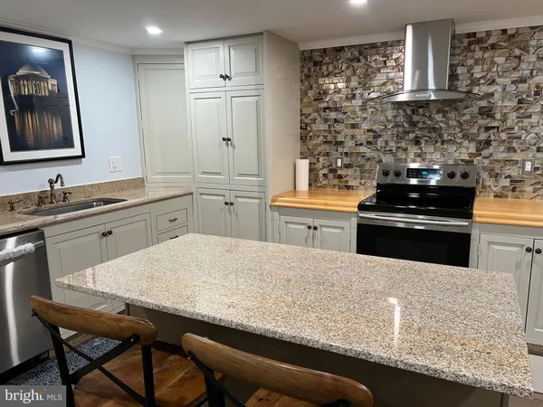 a kitchen with stainless steel appliances granite countertop a sink stove and refrigerator