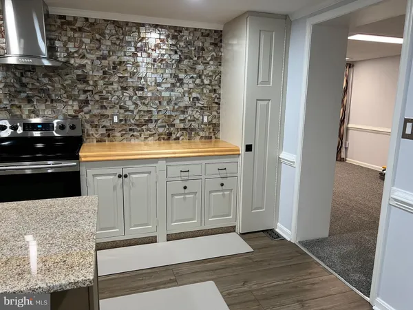 a kitchen with white cabinets and black appliances
